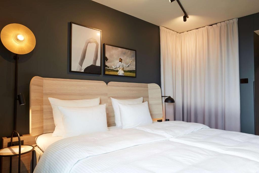 美因河畔法兰克福Scandic Frankfurt Hafenpark的卧室配有白色大床和白色枕头