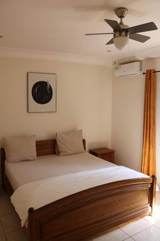 SukutaThe Rink Apartment's的一间卧室配有一张带吊扇的床