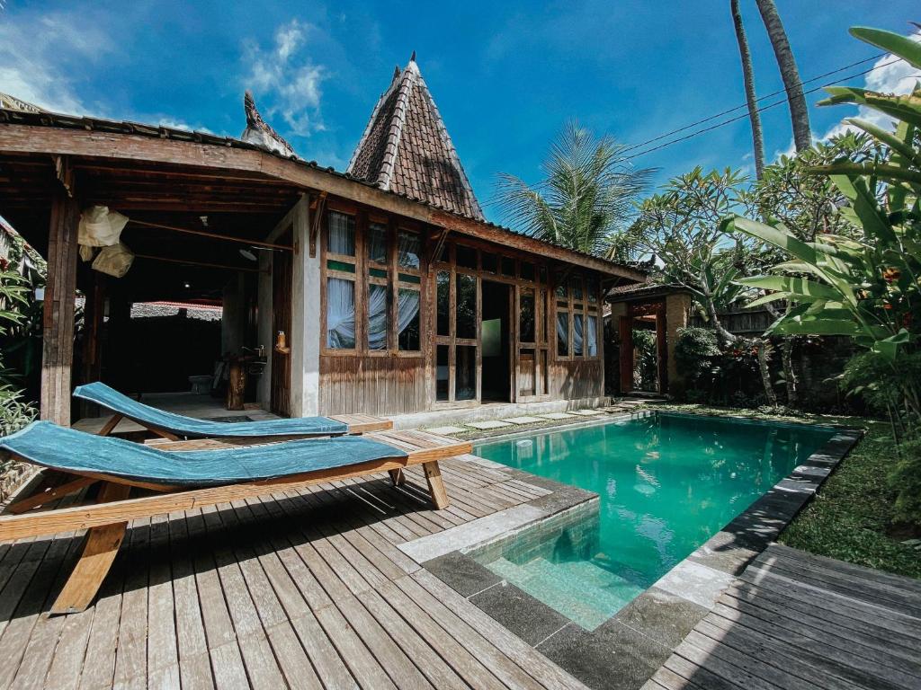 博拉巴图Sarini Villas的一座别墅,设有游泳池和一个木制甲板