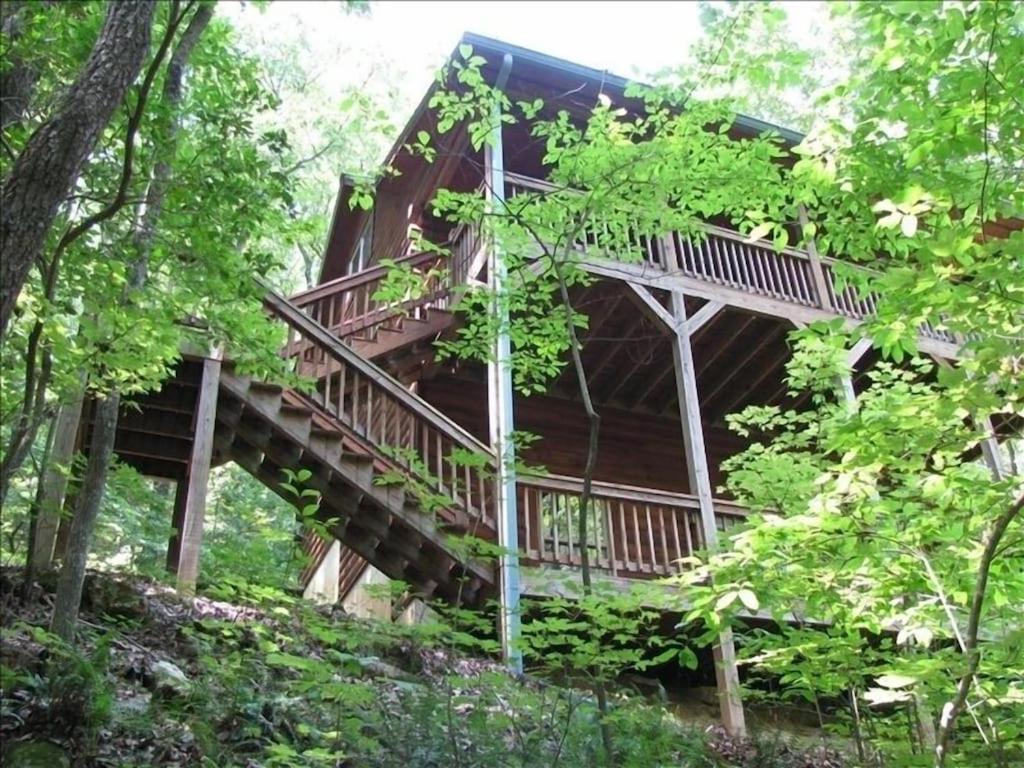 索蒂纳科奇Alpenhaus Cabins Real Log Home in Helen Ga Mountains with hot tub and balconies的树林中的树屋,有楼梯