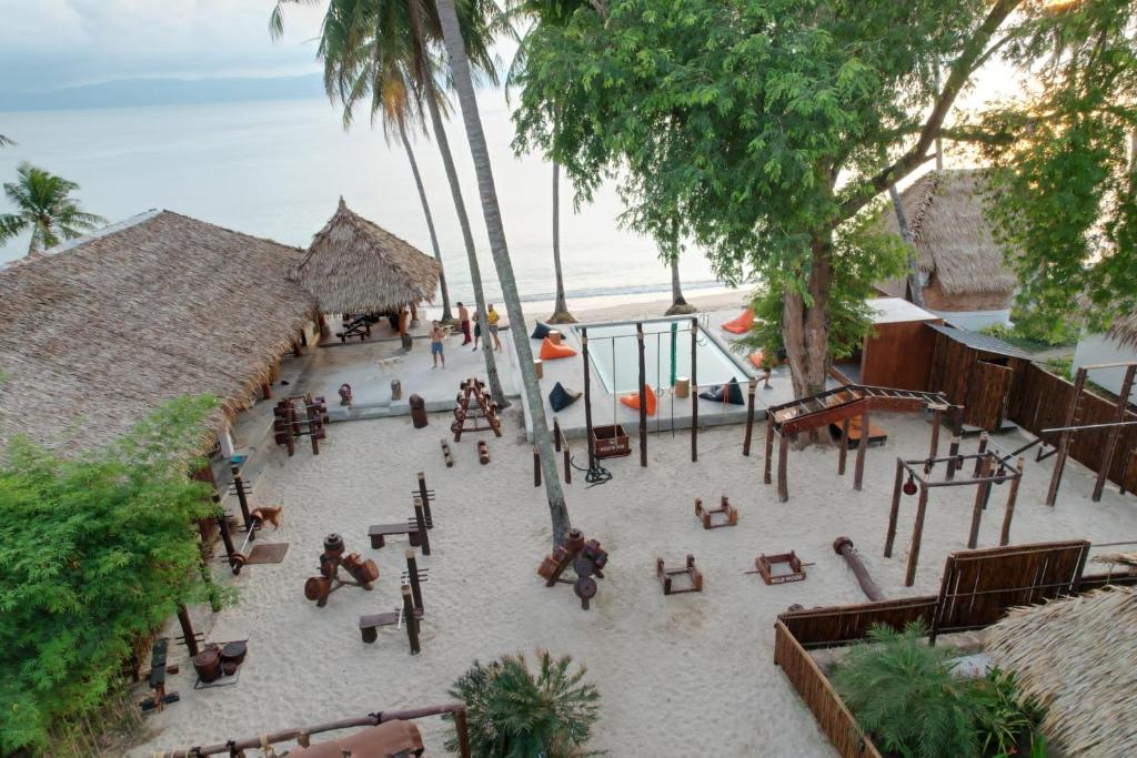 通萨拉Wild Wood x Hansa Beach Fitness Resort的享有海滩的空中景致,配有桌子和长椅