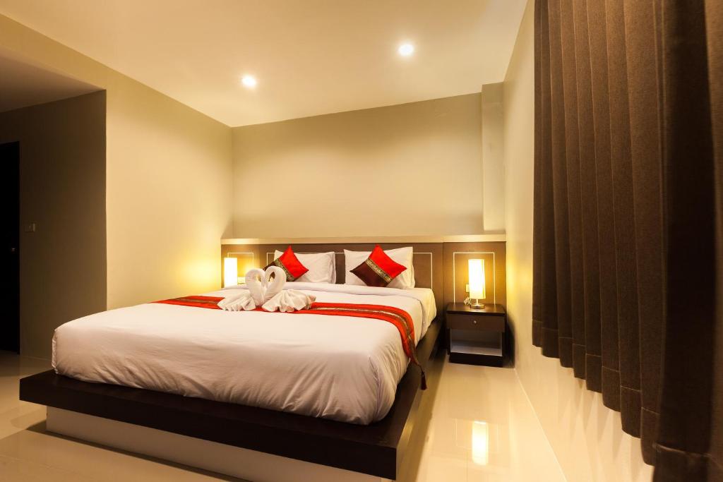 Ban KhaekPranee Home Phang-nga的卧室配有带红色枕头的大型白色床