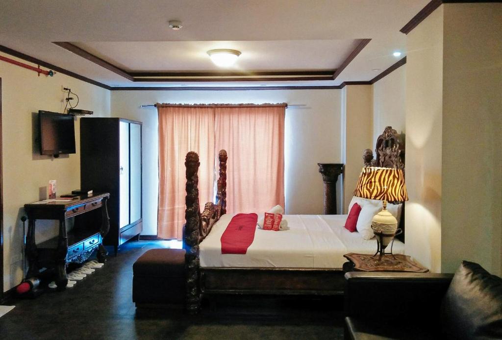 宿务RedDoorz Plus New Era Budget Hotel Mabolo former RedDoorz near Landers Superstore Cebu City的一间卧室配有一张床、一张桌子和一个窗户。