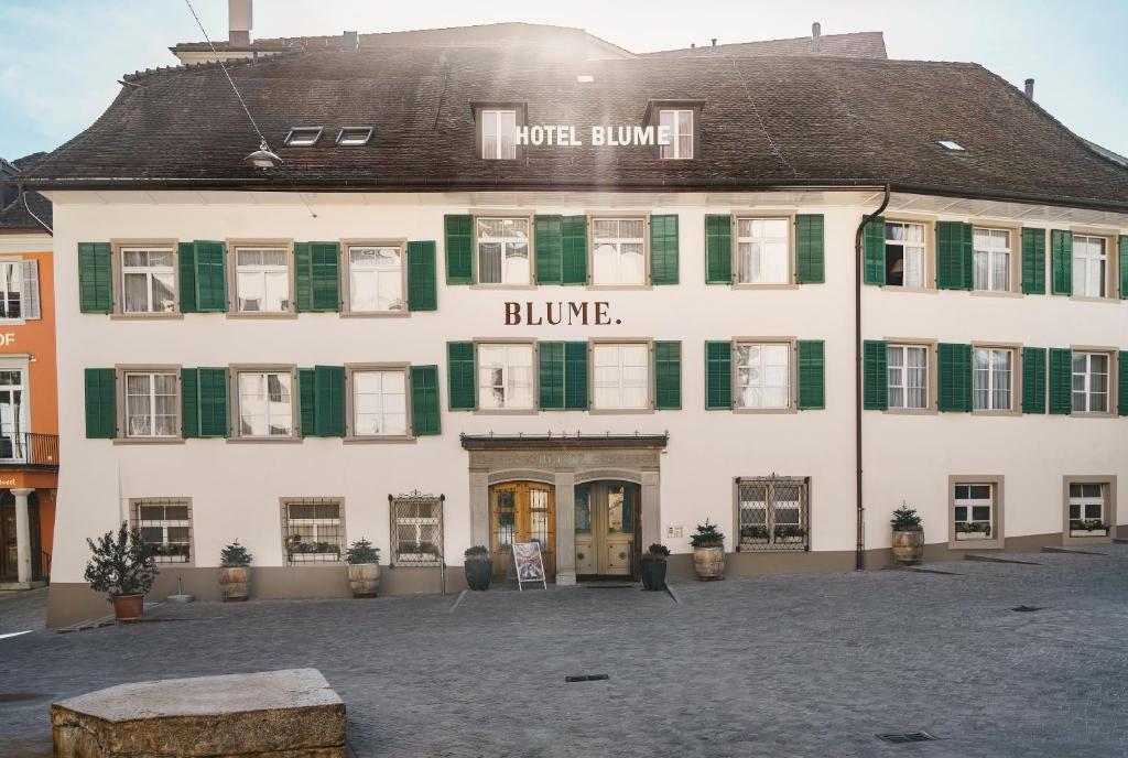 巴登Hotel Blume - Swiss Historic Hotel的一座白色的大建筑,上面有绿色百叶窗