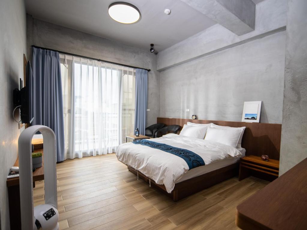 新城48-6民宿的一间卧室设有一张床和一个大窗户