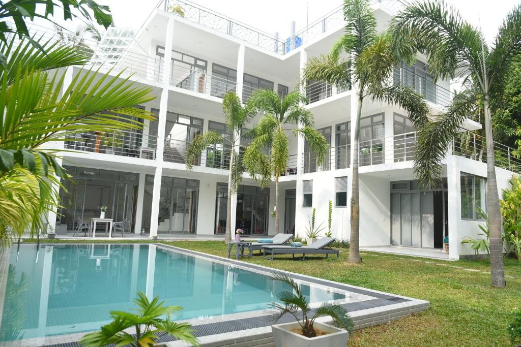 本托塔Eldezo Relax Paradise (Pvt) Ltd的享有带游泳池和棕榈树的建筑的外部景色