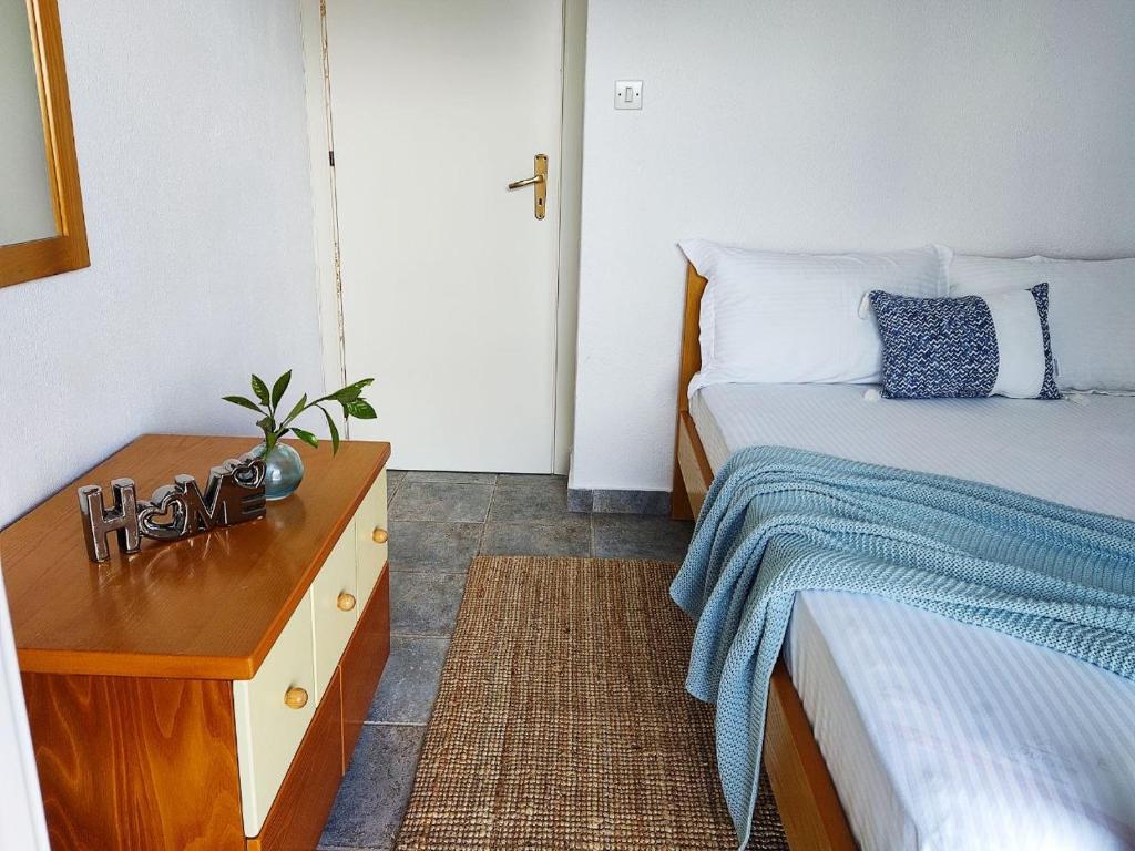 托罗尼Villa Ulyana Toroni - Front seaview, First line, Fireplace的一间卧室配有两张床和一张桌子及床头柜