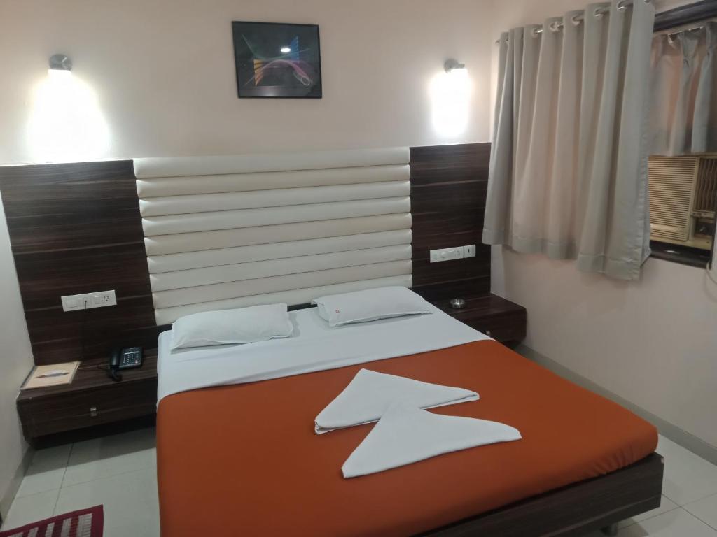 孟买VALA JANU HOTELS PVT LTD的一间卧室配有一张带两个枕头的床