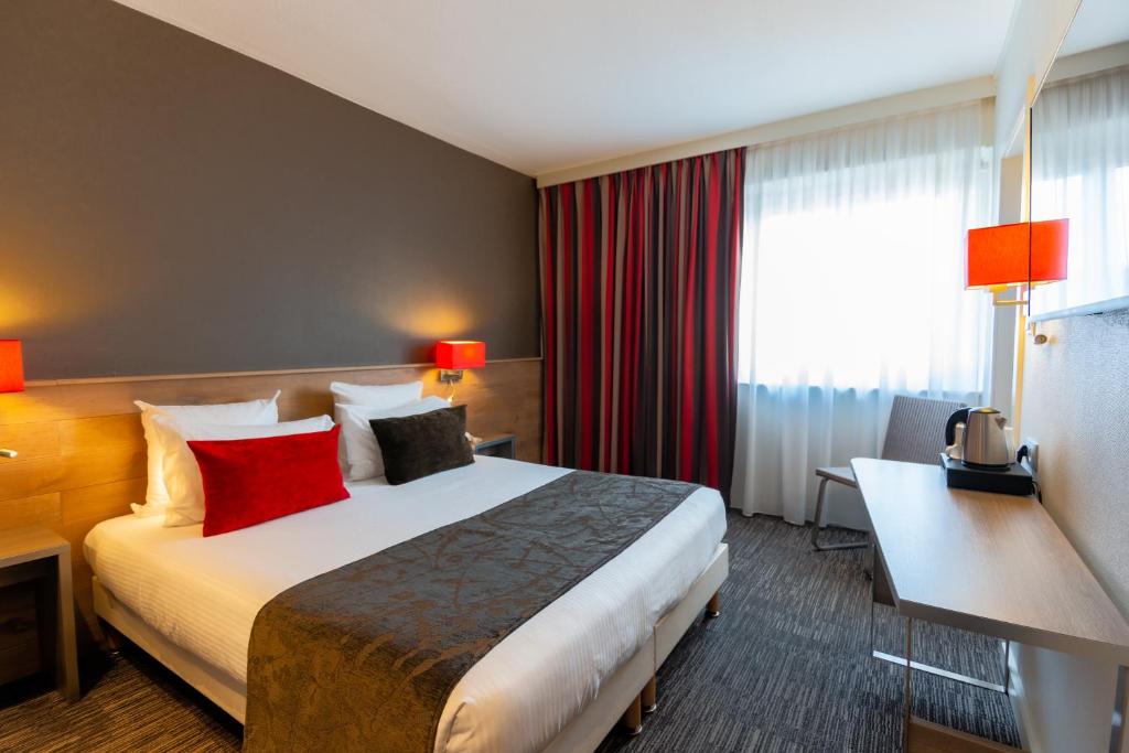 科尔马杜尔那酒店的酒店客房配有一张带红色枕头的大床