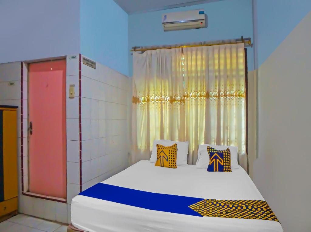 棉兰SPOT ON 92340 Lida Hotel的一间卧室配有一张带窗户的床和一张四柱床
