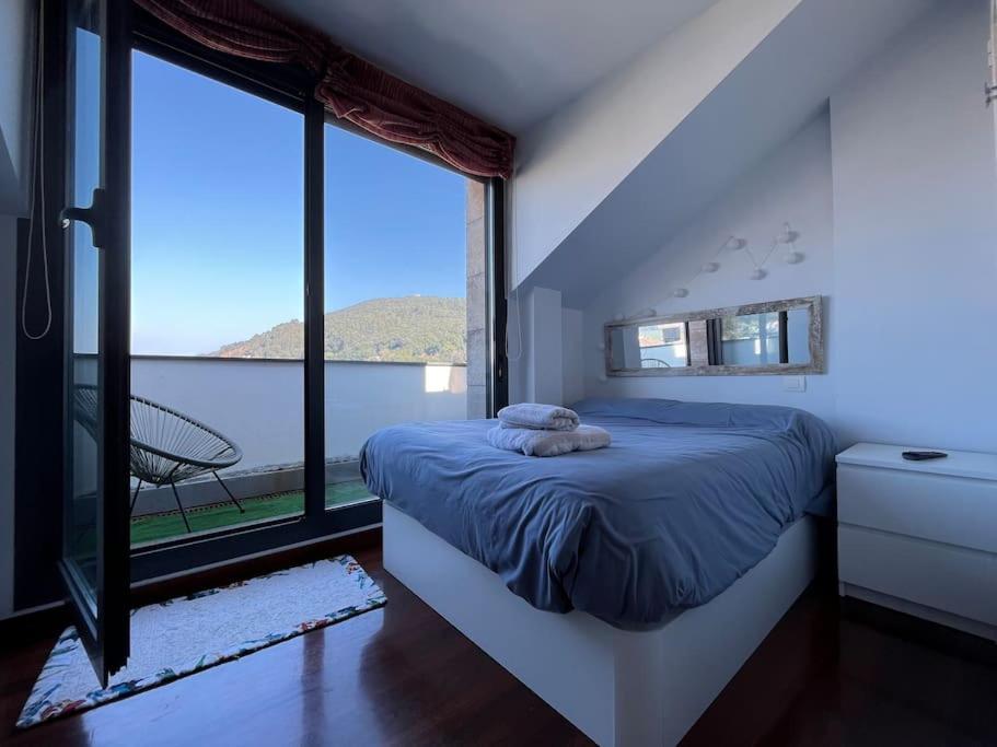桑托尼亚Duplex Bahía de Santoña的一间卧室设有一张床和一个大窗户