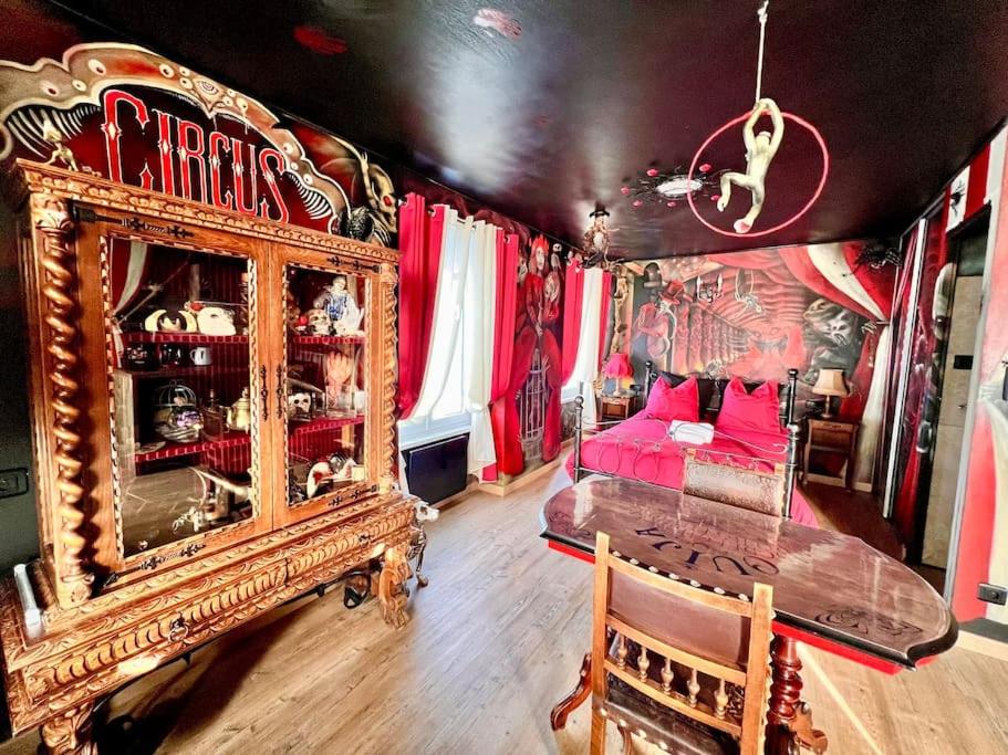 贝尔福Le Cirque Ensorcelé - Le Studio Maudit & Cosy的一间设有床铺和桌子的房间