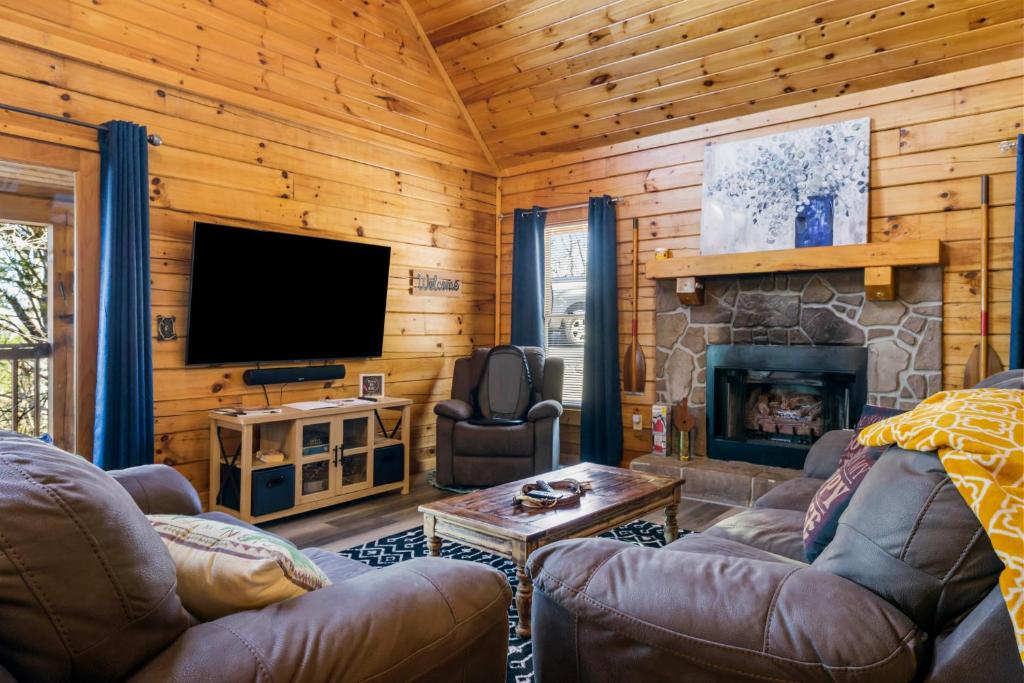 赛维尔维尔Serenity, A Rustic Log Cabin Retreat的一间带电视和壁炉的客厅