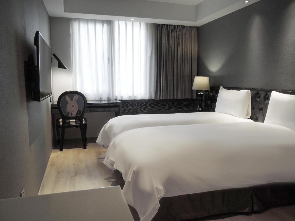 台北雀客旅馆台北站前的酒店客房设有一张白色大床和一个窗户。