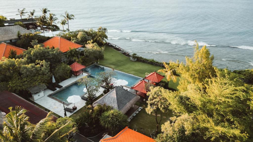 乌鲁瓦图乌鲁瓦图别墅酒店的享有带游泳池和大海的房屋的空中景致
