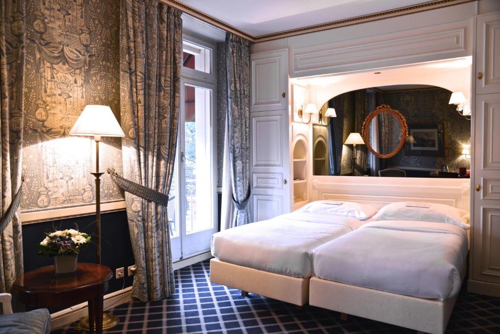 洛桑洛桑卡尔顿精品酒店的一间卧室设有一张大床和一个窗户。