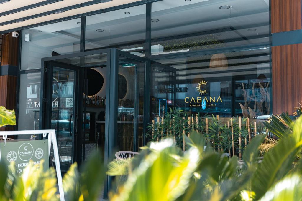 米拉斯Cabana Boutique Hotel & Cafe的餐厅前面有玻璃门和植物