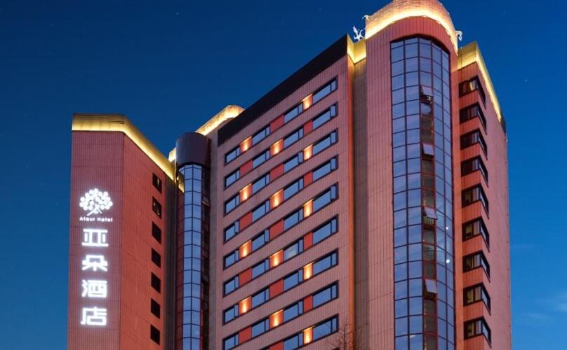 成都成都春熙路亚朵S酒店的一座高大的建筑,旁边灯火通明
