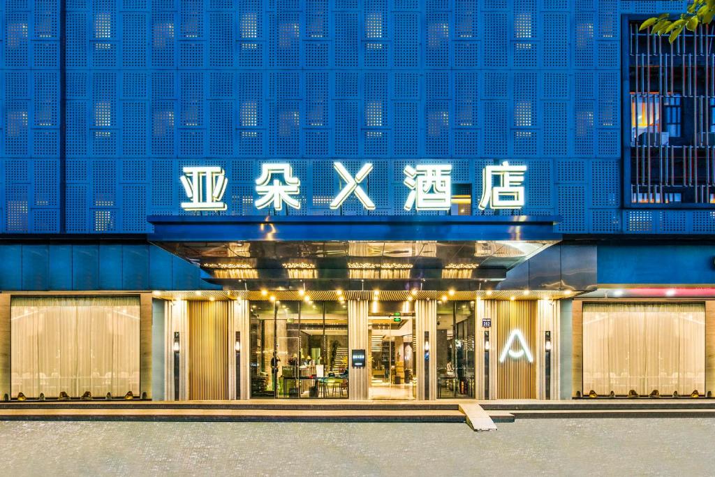 广州广州珠江新城天河公园地铁站亚朵X酒店的蓝色建筑前面的商店,上面写着中国字