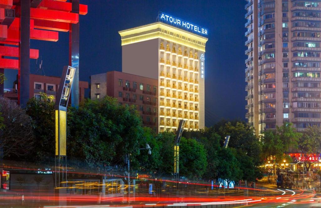 重庆重庆洪崖洞江景亚朵酒店的一座建筑物,上面有夜间标志