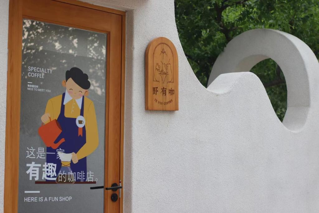 北京北京遇花园休闲度假民宿的门上的标志,女人拿着照相机