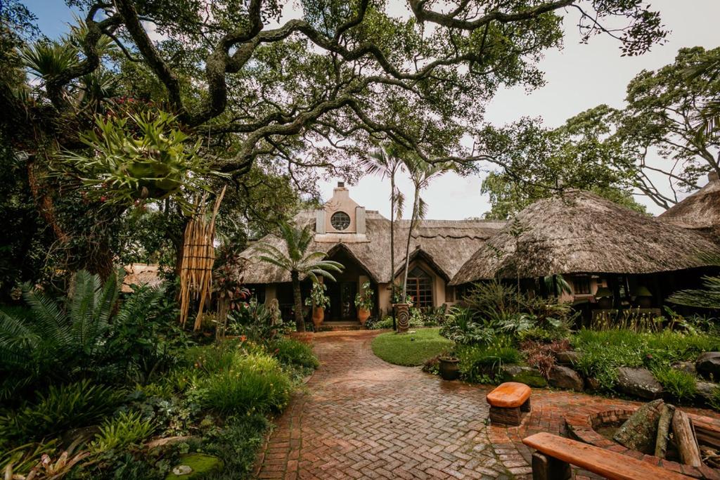 哈拉雷Amanzi Lodge的热带房屋 - 带砖砌走道和树木