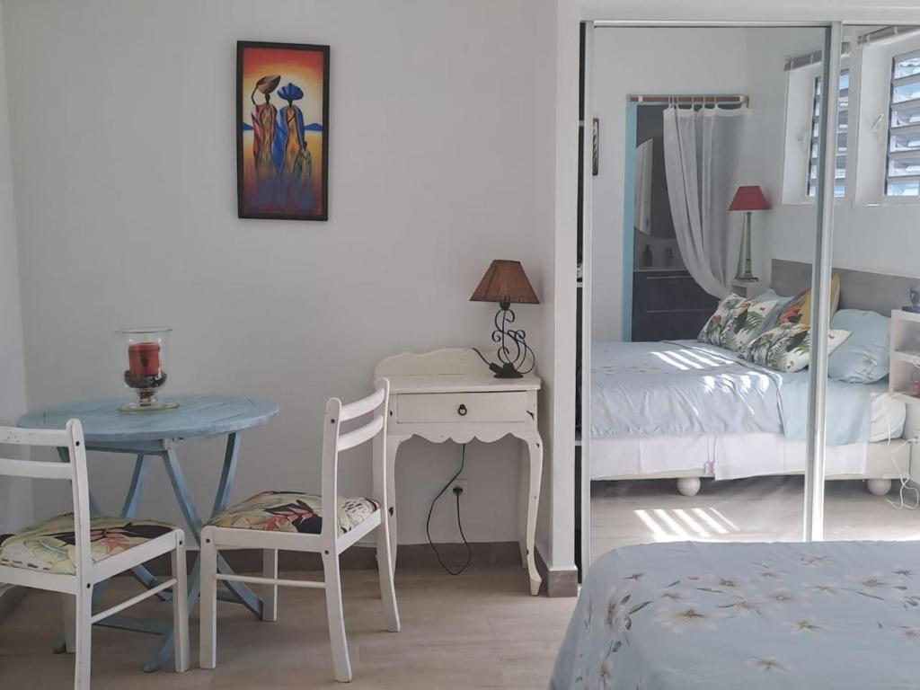 东方湾法国大街Tropical的一间卧室配有桌子、床和镜子