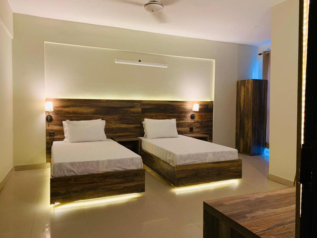 卡拉奇TULIP HOTELS AND APPARTMENTS的一间卧室设有两张床和大镜子