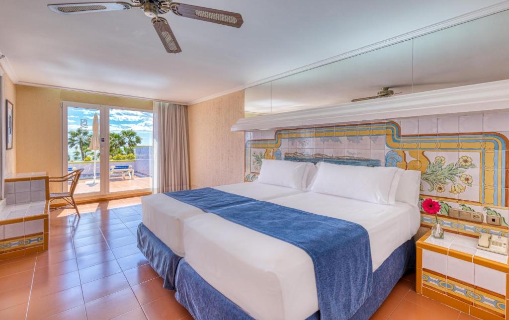 维拉Playavera的一间卧室配有一张带蓝色毯子的大床