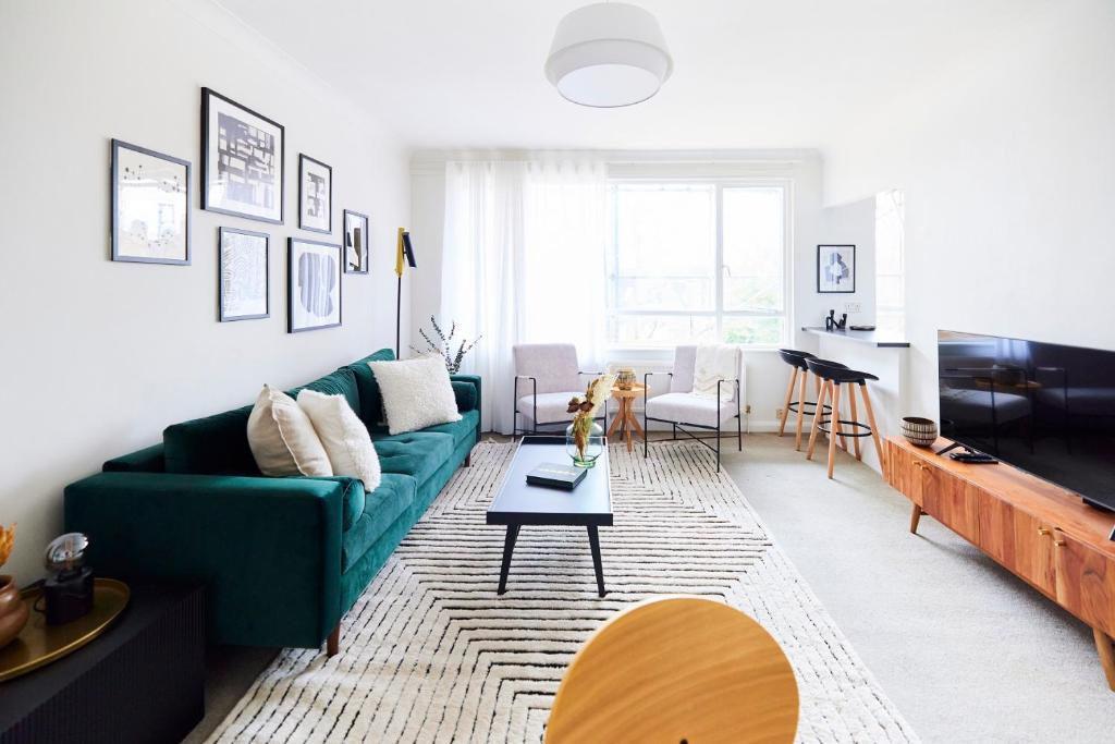 伦敦The London Escape - Modish 1BDR Flat的客厅配有绿色沙发和桌子