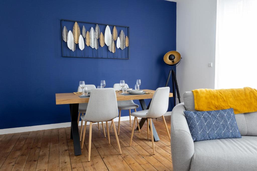 坎佩尔Appartement spacieux的一间设有桌子和蓝色墙壁的用餐室
