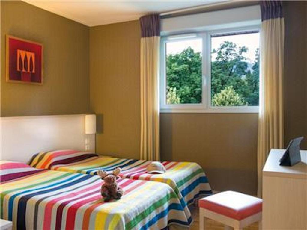 迪沃讷莱班La Villa Du Lac- 3 rooms for 6 people的卧室床上的泰迪熊