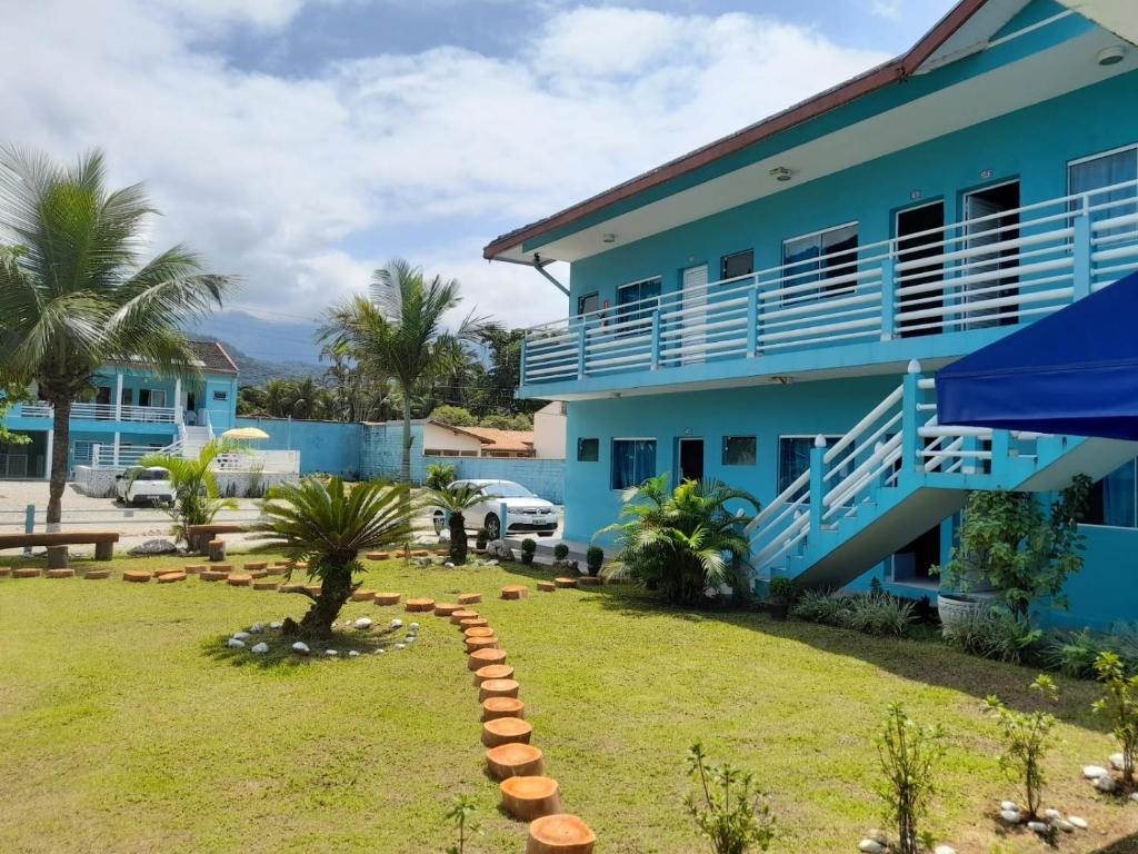 乌巴图巴Chalés Céu e Mar Ubatuba的前面有草坪的蓝色房子