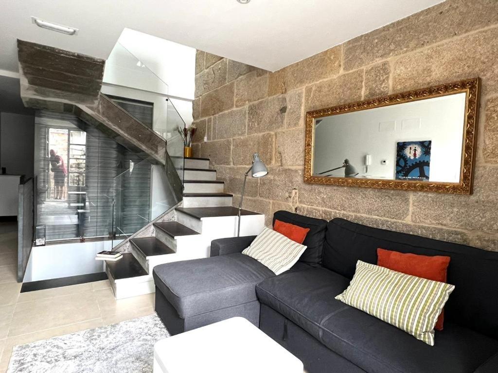 庞特维德拉Casa Cousiño Zona Monumental的带沙发和石墙的客厅