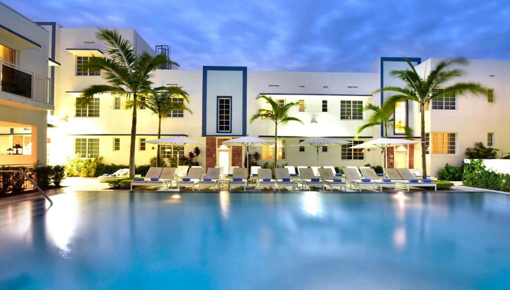 迈阿密海滩佩斯塔纳南滩酒店的一座带椅子的游泳池以及一座建筑