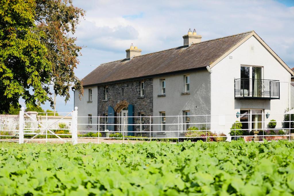 瑟勒斯The Granary, Luxuriously Restored Barn on a Farm的前面有栅栏的白色房子