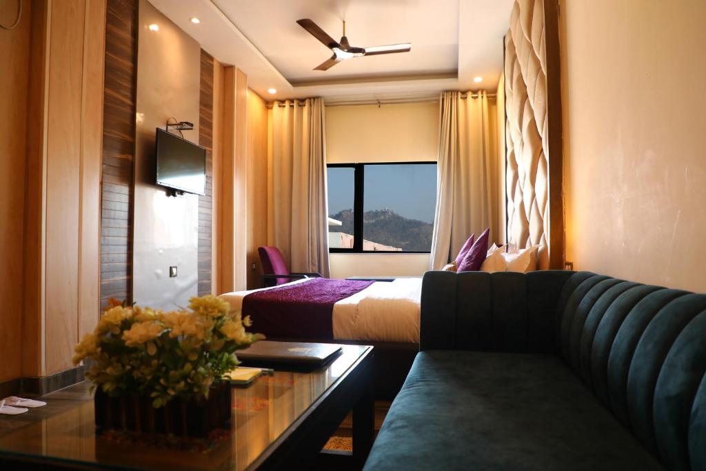 哈里瓦Perfectstayz Premium @Harkipauri Road的酒店客房,配有床和沙发
