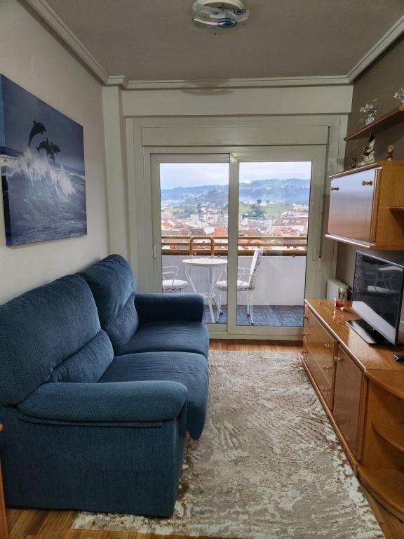 奥伦塞Estudio con vistas a la ciudad的客厅设有蓝色的沙发和大窗户