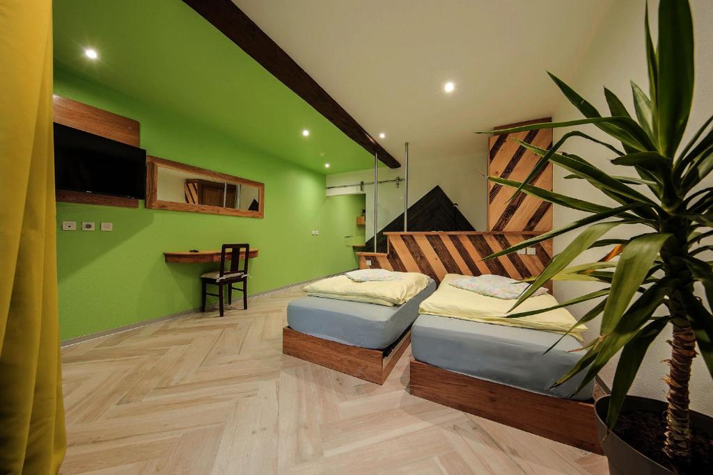 OsenbachLe Domaine du Verger, Chambres et SPA prive的绿色的客房设有两张床和盆栽植物