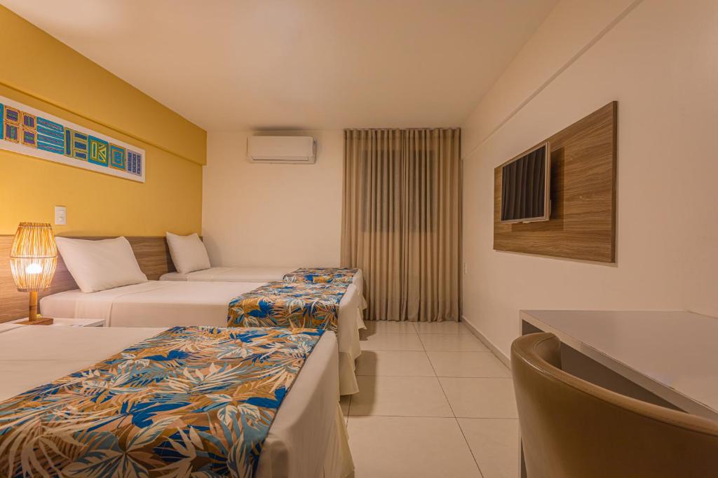 马塞约Slim Pajuçara by Tropicalis的酒店客房,设有两张床和一张沙发