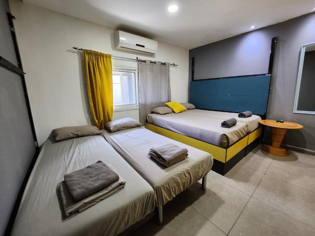埃拉特Amdar Hostel的一间卧室设有两张床、一个窗口和一张桌子