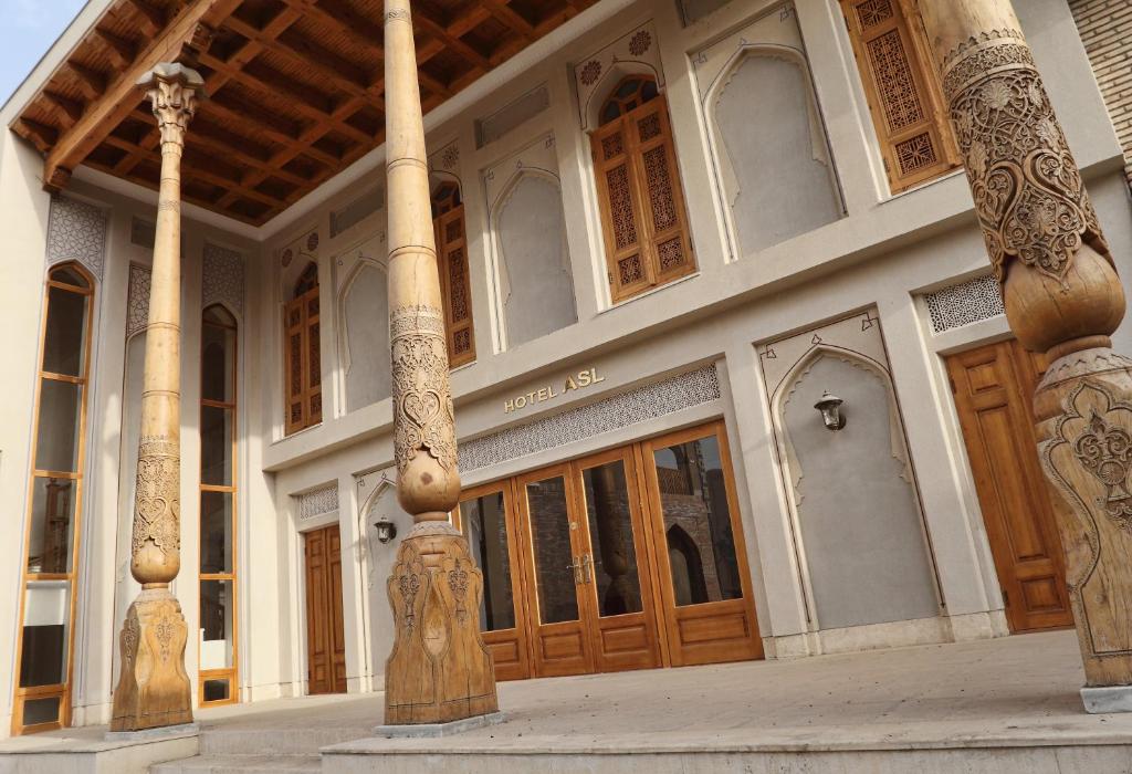 布哈拉翔升酒店 的一座带木门和柱子的大型建筑