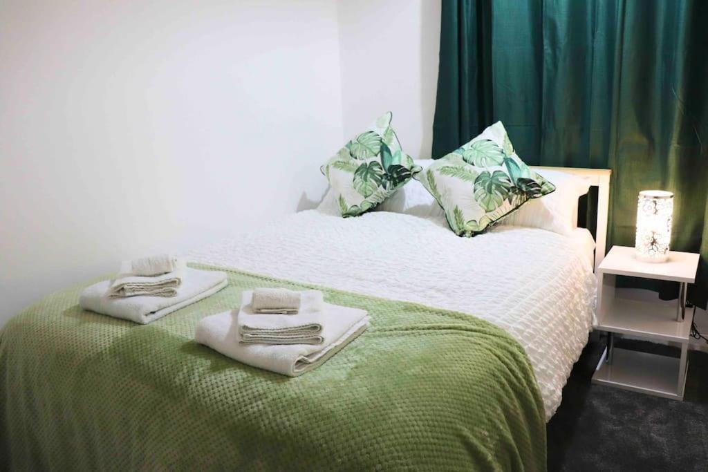 KnowsthorpeUnique 3 Bedroom House FREE WiFI & Parking的一间卧室配有带毛巾的床