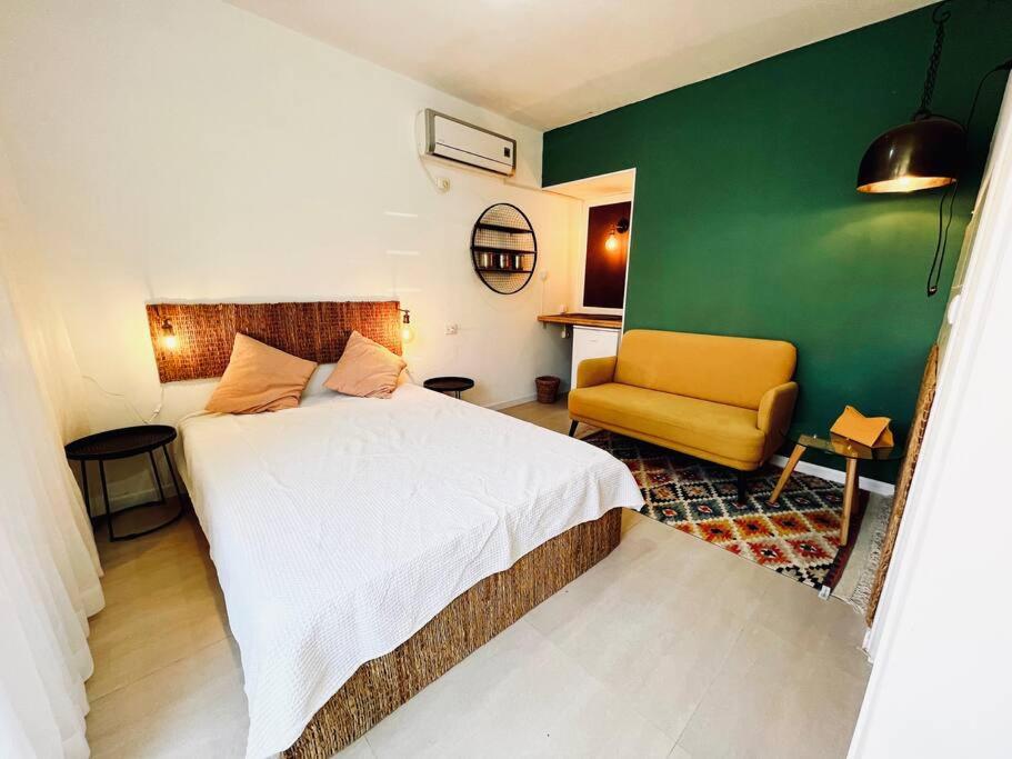 埃拉特Eilat charming & cozy Studio的卧室配有白色的床和绿色的墙壁