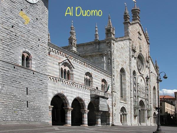 科莫Al Duomo guest house的一座大型砖砌建筑,上面有时钟