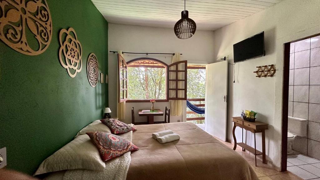 马卡科斯Sensorial Macacos的一间卧室设有一张带床铺的绿色墙壁