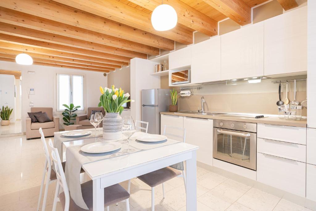 威尼斯Ca' Degli Antichi Giardini Apartments的白色的厨房配有白色的桌子和椅子