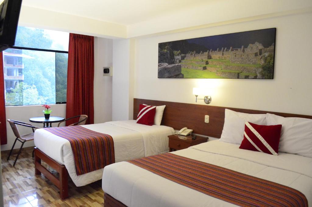 马丘比丘Viandina Machupicchu的酒店客房设有两张床和一张桌子。