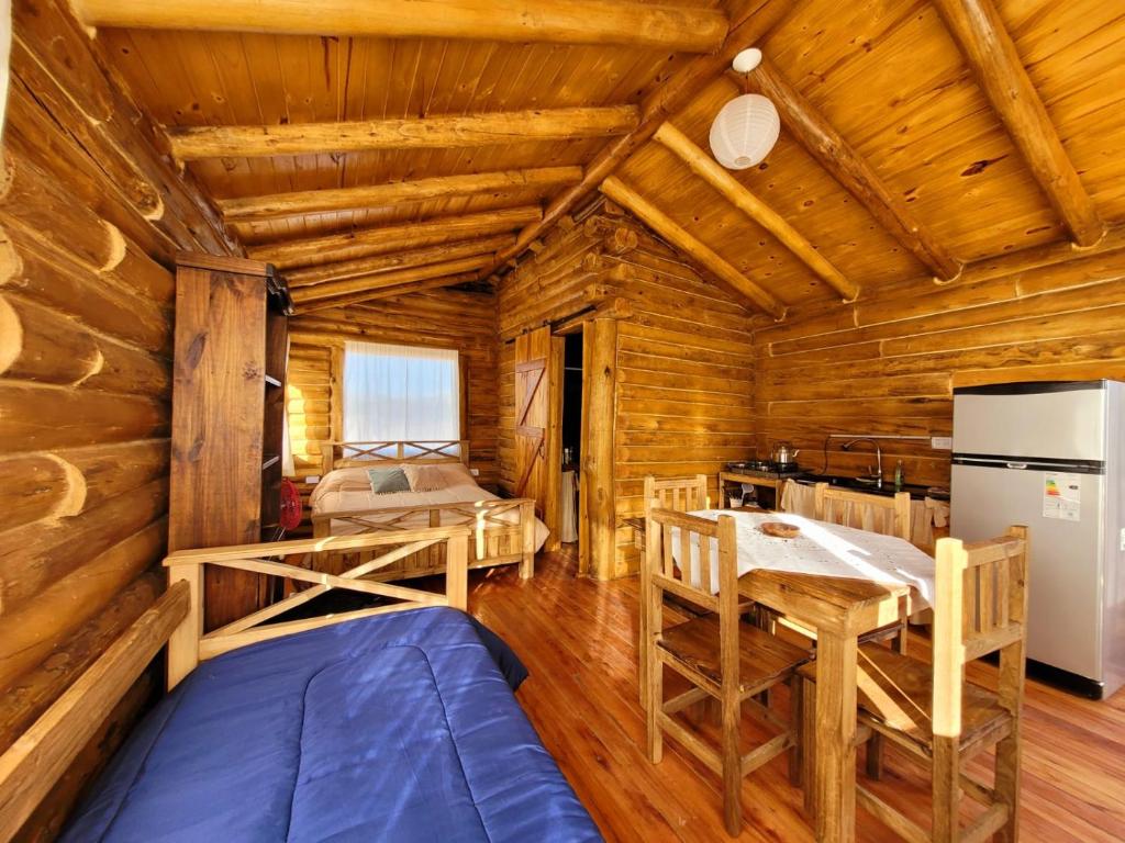 乌斯帕亚塔Paramitas - cabañas y hostel de montaña的小木屋设有用餐室和厨房