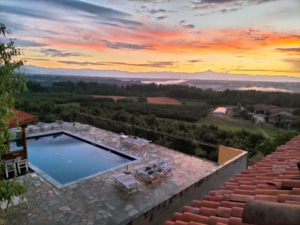 ClavesanaIl Palazzetto的一座游泳池,位于一座享有日落美景的房屋的顶部